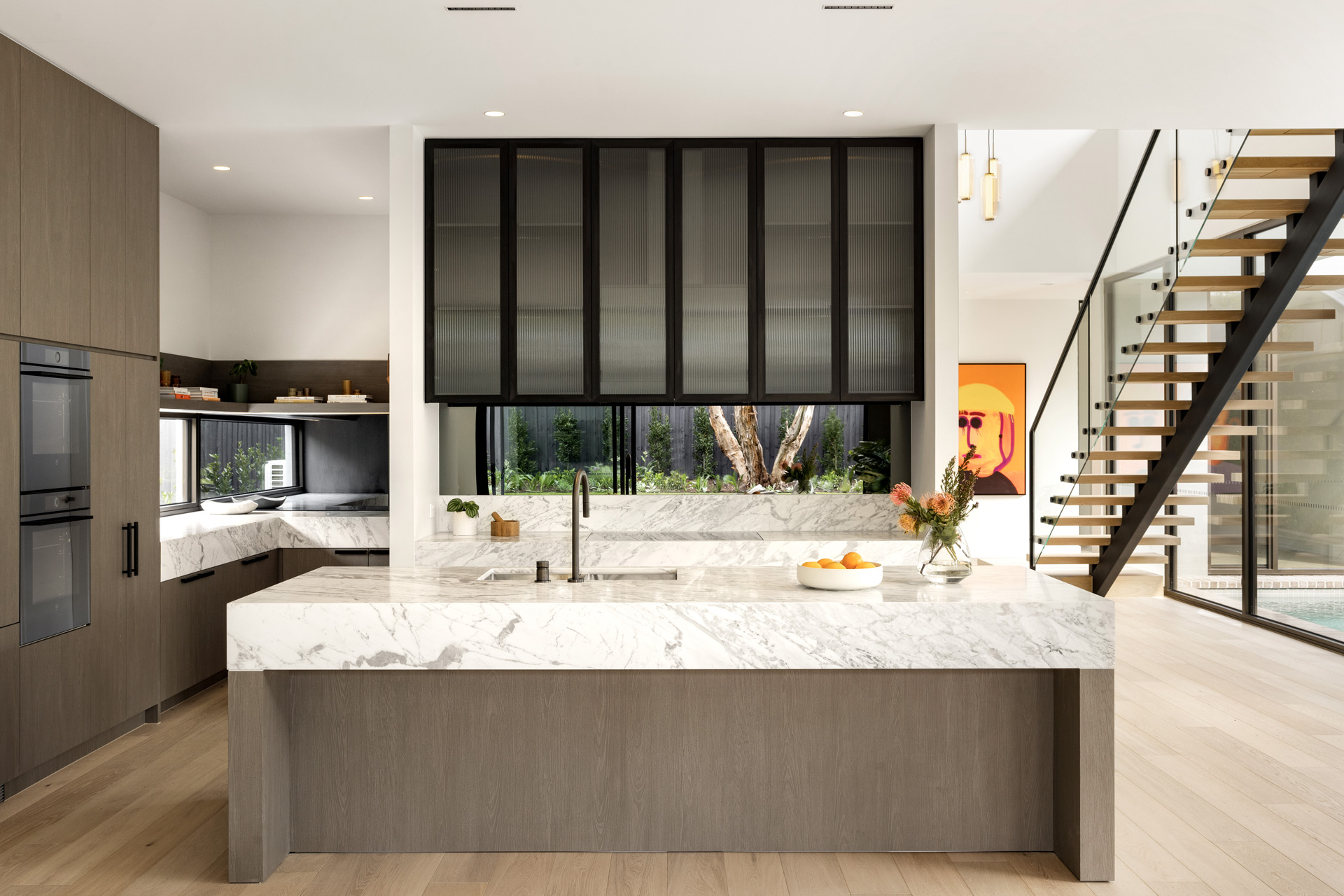 A straight on shot of the kitchen featuring marble benchtops