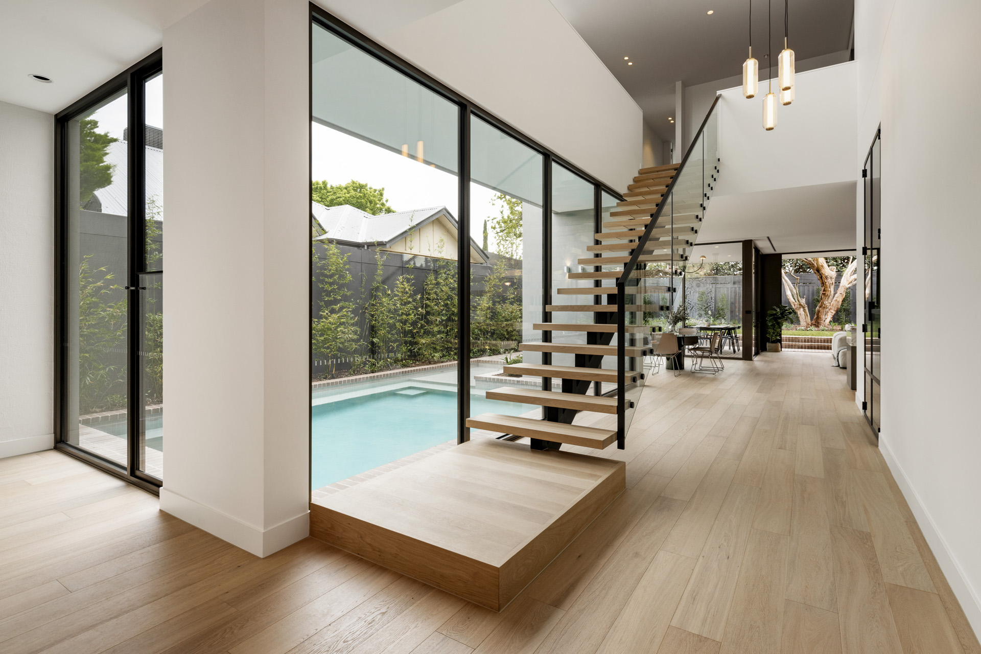 An inside shot featuring the staircase and a view out to the pool area